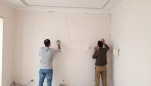 عمال يقومون بترميم جدران داخلية في منزل بمنطقة العدان عمال يقومون بترميم جدران داخلية في منزل بمنطقة العدان